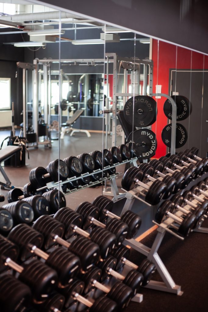 Hylla med hantlar framför spegel